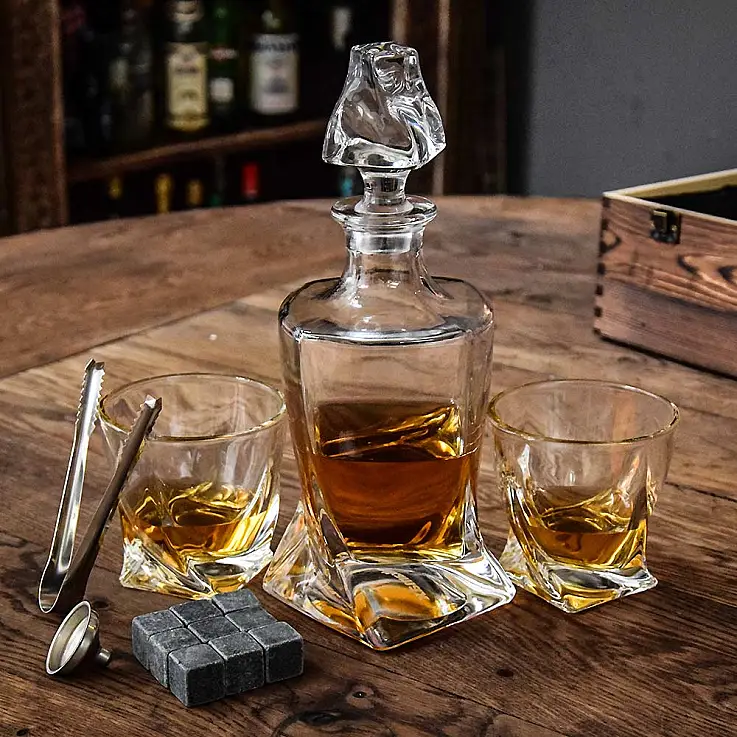 Include un decanter, due bicchieri, nove pietre per il raffreddamento del whisky, un imbuto e delle pinze. 